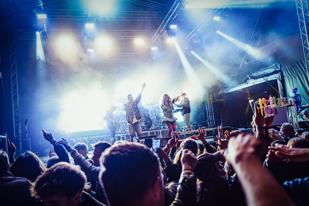 Publiek met de handen omhoog voor het verlichte Monkey Squad-podium